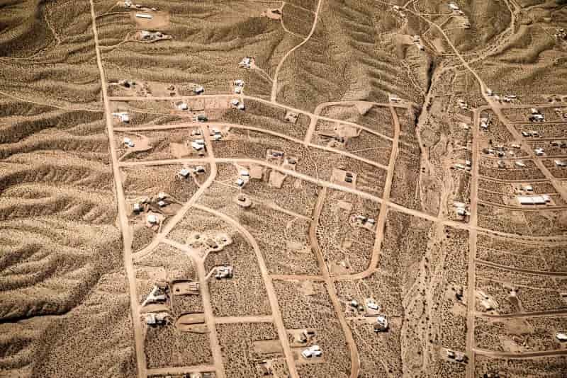Luchtfoto van vertakkende lijnen in de Mojavewoestijn als metafoor voor verschillende routes naar uitstelgedrag.